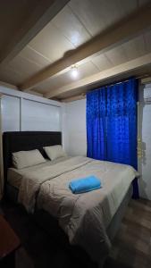 a bed with a blue pillow on top of it at Dibi Krui Surf in Krui