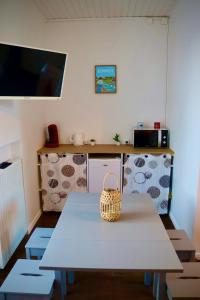 une cuisine avec une table et un panier dans l'établissement Chambre d'hôtes rénovée du XVIII ème, à Saint-Aubin-la-Plaine