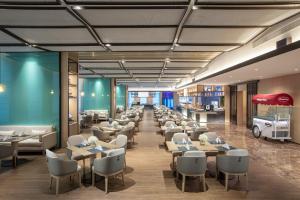 a restaurant with tables and chairs and a cafeteria at Wyndham Handan Congtai in Handan