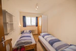 une chambre avec trois lits dans une pièce dans l'établissement Chesa Talvo, à Samedan 8 autres photos