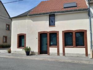 a white building with brown windows and a red roof at Gîte Dameryat in Damery