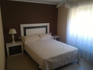 a bedroom with a white bed and a window at Maison Puigpelat in Puigpelat
