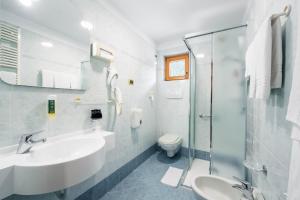 ein weißes Badezimmer mit Waschbecken und Dusche in der Unterkunft EL CIASEL in Canazei + 17 Fotos