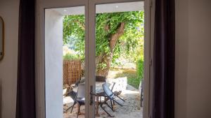 une porte coulissante en verre avec une table et des chaises à l'extérieur. dans l'établissement La Maison des Hôtes, à La Motte-du-Caire