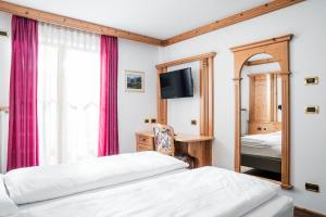 ein Schlafzimmer mit zwei Betten und einem Spiegel in der Unterkunft EL CIASEL in Canazei