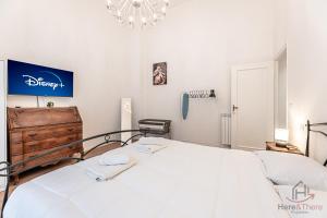 una camera da letto con un grande letto bianco e un lampadario a braccio di New Modern Apt- Center 10min - Hiper WiFi - A-C a Genova