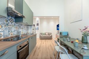 una cucina con un bancone e sedie in una stanza di New Modern Apt- Center 10min - Hiper WiFi - A-C a Genova