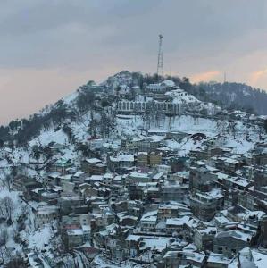 une ville recouverte de neige au sommet d'une montagne dans l'établissement Al Maz Hotel Mall Road, à Dargai 10 autres photos