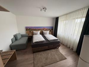 une chambre avec un lit, un canapé et une chaise dans l'établissement Gästehaus Eberlein, à Rothenburg ob der Tauber