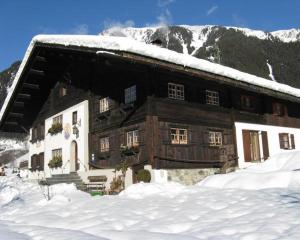 Haus Lucas Tschofen في Aussergosten: مبنى خشبي كبير عليه ثلج