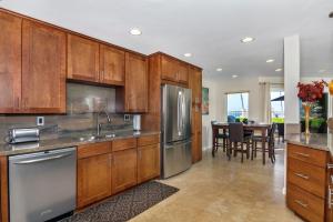 une cuisine avec des armoires en bois et des appareils en acier inoxydable dans l'établissement 5N-53 Beach Bliss Ocean Views, à Oceanside