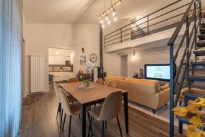 a dining room and living room with a table and a couch at 3 MURA rooms in Teulada