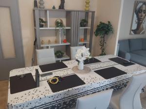 einen Tisch mit schwarzen und weißen Platten und Blumen darauf in der Unterkunft F5 lumineux et moderne Le confort parfait pour familles et couples, Perpignan in Perpignan