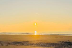 een zonsondergang op het strand met zonsondergang bij Texel Atelier in De Koog