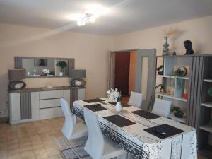 ein Esszimmer mit einem Tisch und weißen Stühlen in der Unterkunft F5 lumineux et moderne Le confort parfait pour familles et couples, Perpignan in Perpignan