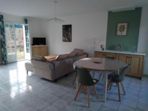 a living room with a table and a couch at Bruyéres in Lesperon
