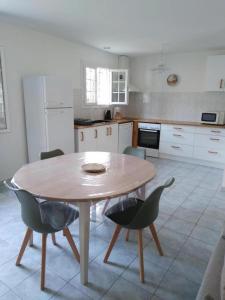 eine Küche mit einem Holztisch und Stühlen in der Unterkunft Bruyeres in Lesperon