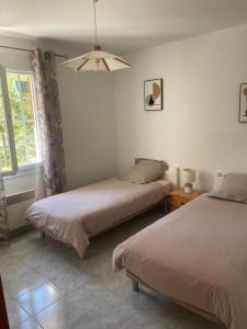 ein Schlafzimmer mit zwei Betten und einem Fenster in der Unterkunft Bruyeres in Lesperon