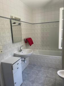 ein weißes Badezimmer mit einem Waschbecken, einer Badewanne und einem Waschbecken in der Unterkunft Bruyeres in Lesperon