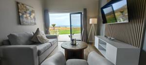 a living room with a couch and a tv and a table at Black Eagle's Rest #Unit 1-8 in Langebaan