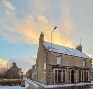 - un bâtiment en brique dans une rue éclairée dans l'établissement Weston House Keith, à Keith