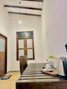 达瓦拉维Blue Bird Udawalawe的一张木桌,上面有盘子和杯子