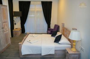 ein Schlafzimmer mit einem großen Bett und einem lila Stuhl in der Unterkunft King Castle Lake Front By Laksam in Nuwara Eliya