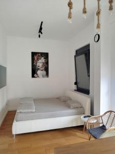 a white living room with a couch and a tv at Xenia in Petrovaradin