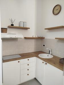 a kitchen with a sink and a clock on the wall at Xenia in Petrovaradin