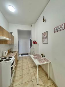 a kitchen with a stove and a table in it at Pokoje przy Rynku III in Katowice