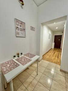 a white table in a room with a hallway at Pokoje przy Rynku III in Katowice