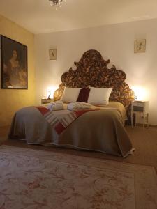 ein Schlafzimmer mit einem großen Bett mit einem großen Kopfteil aus Holz in der Unterkunft Manoir de Kerledan in Carhaix-Plouguer + 26 Fotos