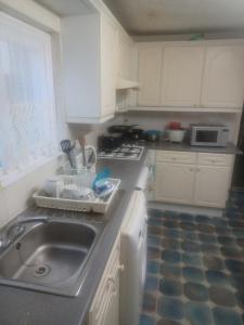 a small kitchen with a sink and a stove at Cozy King Room with Shared Kitchen & Bathroom in Lewisham