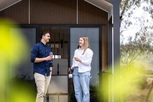 Ein Mann und eine Frau stehen vor einem Haus. in der Unterkunft Seabrook Vineyard Retreat  + 2 Fotos