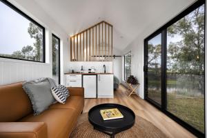 ein Wohnzimmer mit Sofa und Tisch in der Unterkunft Seabrook Vineyard Retreat 