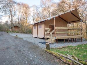 ein Gebäude mit Dach am Rande einer Schotterstraße in der Unterkunft Cobleland Campsite in Gartmore
