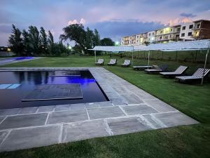 a swimming pool in a yard with chairs and a building at Iconyc Apartment in Brentwood Park