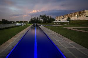 a pool of blue water with a building in the background at Iconyc Apartment in Brentwood Park