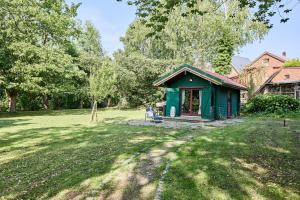 a green shed in the middle of a yard at Das Wewelsflether Bäckerhaus - 250qm für 12 Gäste in Wewelsfleth