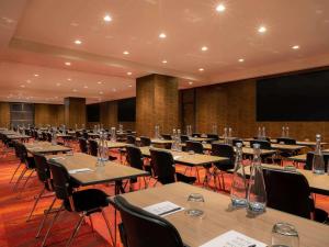 a conference room with tables and chairs and a screen at SO/ Auckland in Auckland +193 photos