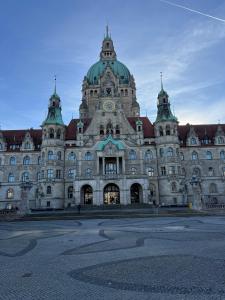 ein großes Gebäude mit einer Uhr oben drauf in der Unterkunft Zweitbettzimmer Two-bed room in Hannover