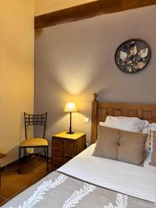a bedroom with a bed and a clock on the wall at Casa Rural El Regajo in Tenzuela