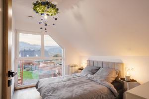 a bedroom with a bed and a large window at Domki u Duszy in Brenna