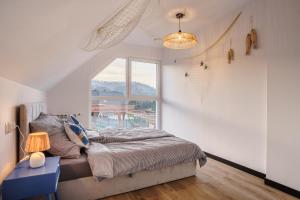a bedroom with a bed and a large window at Domki u Duszy in Brenna +57 photos