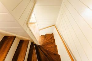 una escalera en una casa con suelos de madera en 長崎観光の拠点に最適グラバー園近くの一軒家ステイ, en Nagasaki 73 fotos más
