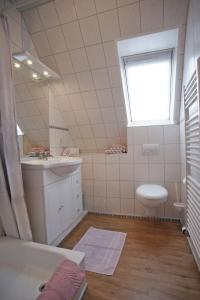 un bagno con lavandino, WC e finestra di Silbermöwe a Fehmarn