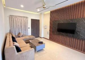 a living room with a couch and a flat screen tv at City View Residence in Islamabad +6 photos