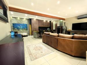 Una sala de estar con un sofá grande y un bar. en 40 On Jacopever, en Richards Bay