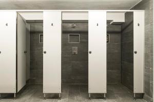 una fila di porte in un bagno piastrellato di Monteurhaus a Hausham