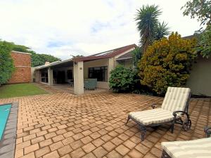 Un patio de ladrillo con una silla y una casa. en 40 On Jacopever, en Richards Bay